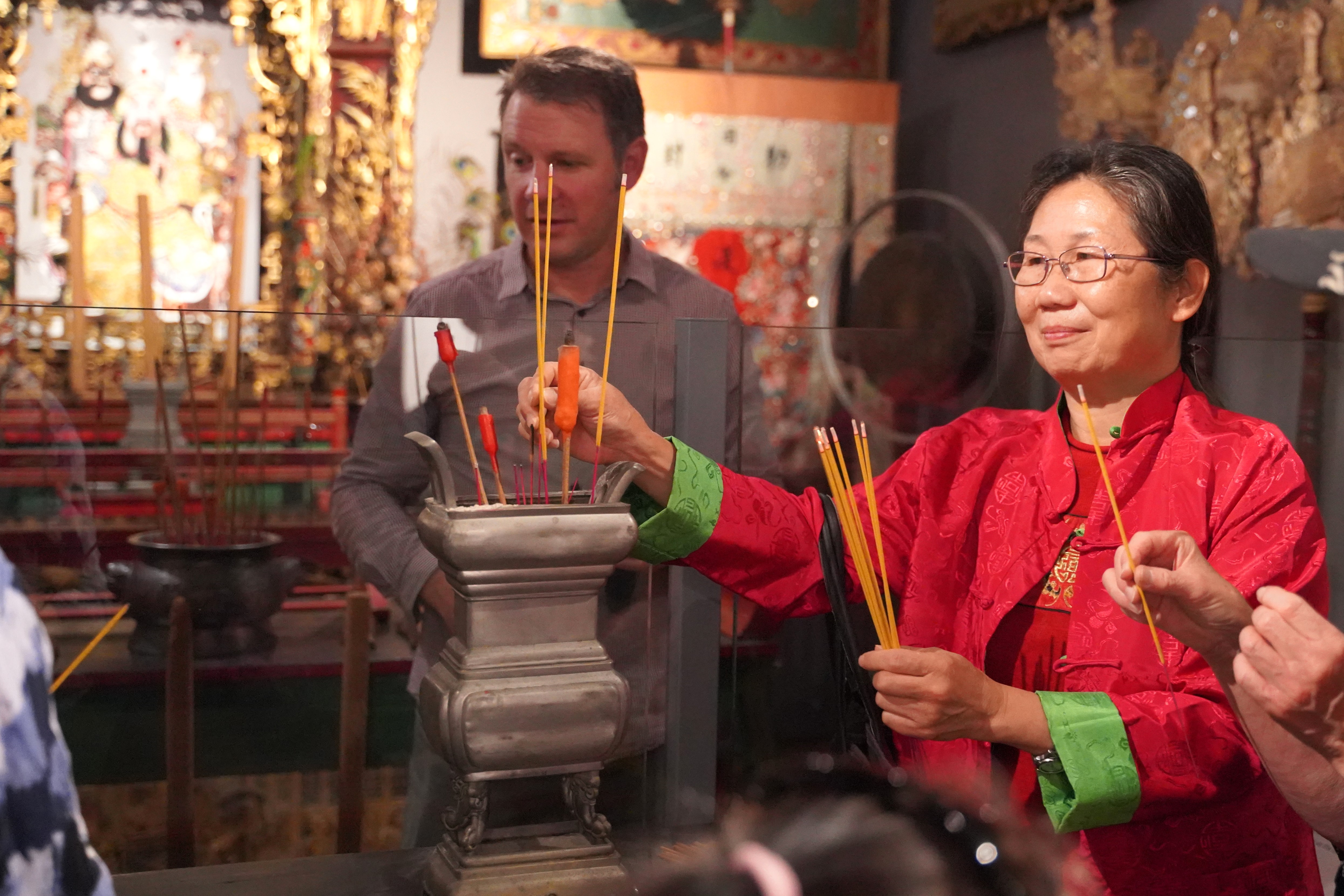 Lighting an incense stick in the Guan Di Temple during the 2024 Lunar New Year celebration