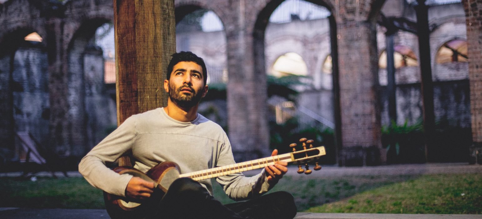 Musician Hamed Sadeghi holding a guitar